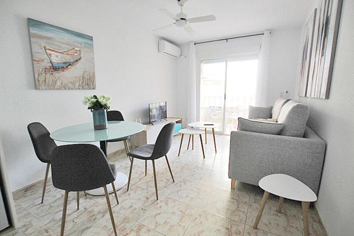 sala de estar con mesa, sillas y sofá en APN Apartamento Playa de Guardamar, en Guardamar del Segura