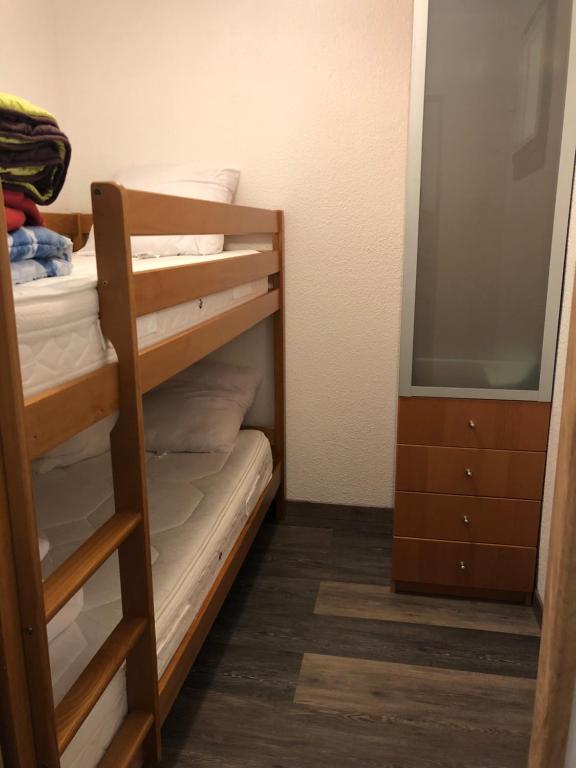 sypialnia z łóżkiem piętrowym, komodą i lustrem w obiekcie Appartement vue mer le barcares w mieście Le Barcarès