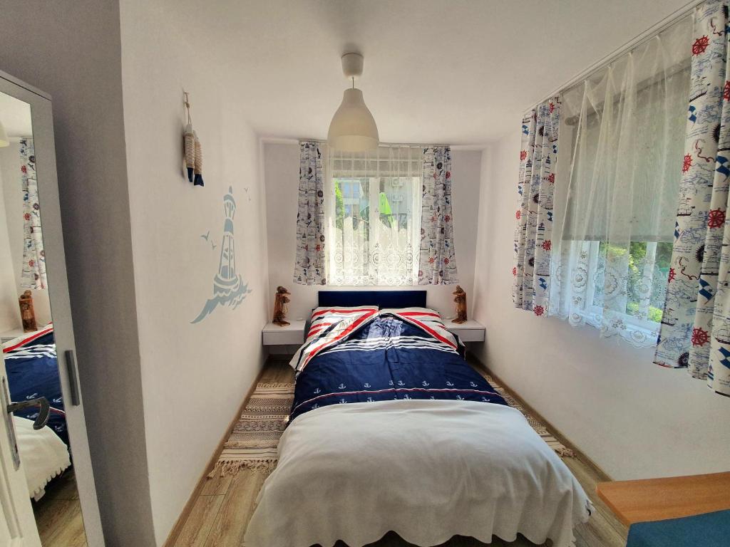 a small bedroom with a bed in the corner at Słonecznik Jastarnia. Domek na Zdrojowej. in Jastarnia