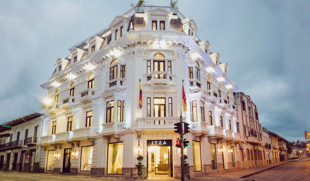 a large white building on the corner of a street at Itza Hotel Boutique Internacional in Cuenca