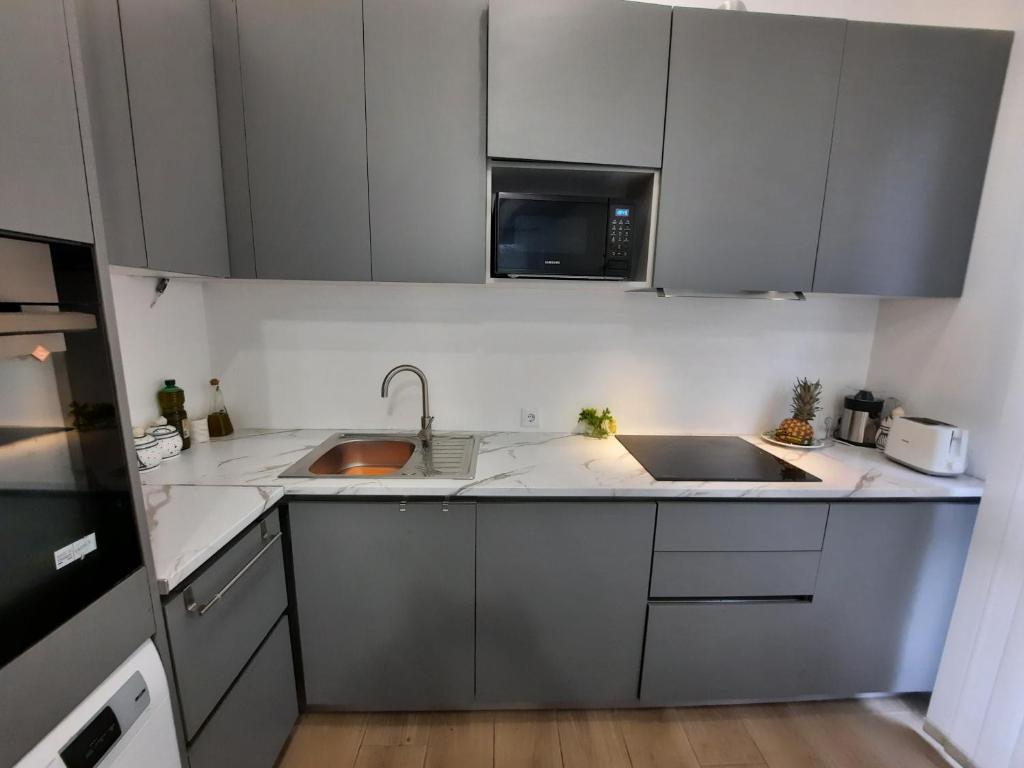 a kitchen with white cabinets and a sink and a microwave at josemaenea in Pamplona