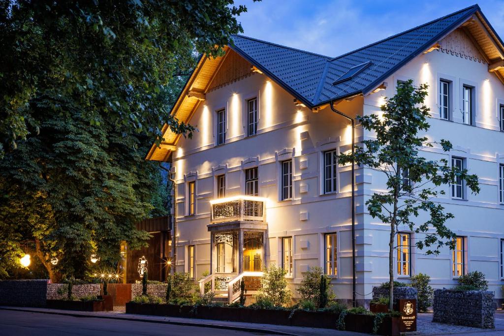 een wit gebouw met een blauw dak bij Boutique Hotel Sunrose 7 - Gourmet & SPA in Bohinj
