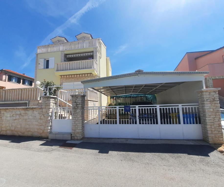 una casa con una puerta blanca y un edificio en Apartmani Anita, en Brodarica