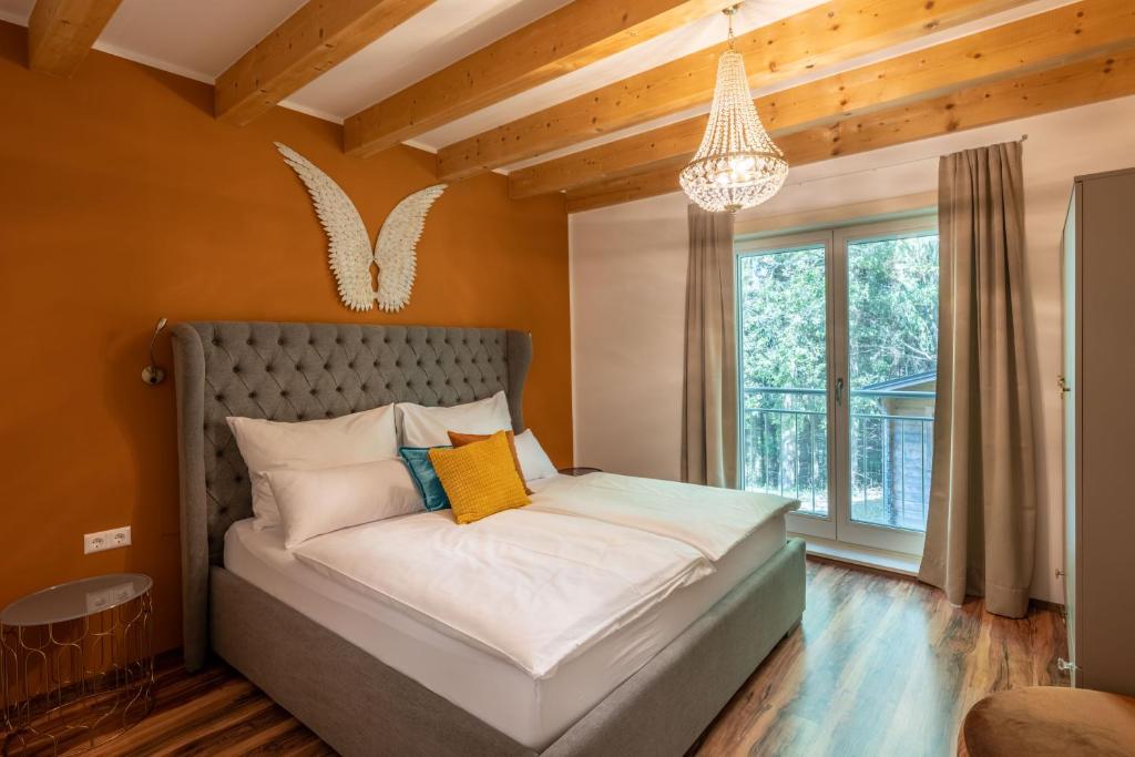 1 dormitorio con cama y lámpara de araña en Ferienhaus Melita en Bleiburg