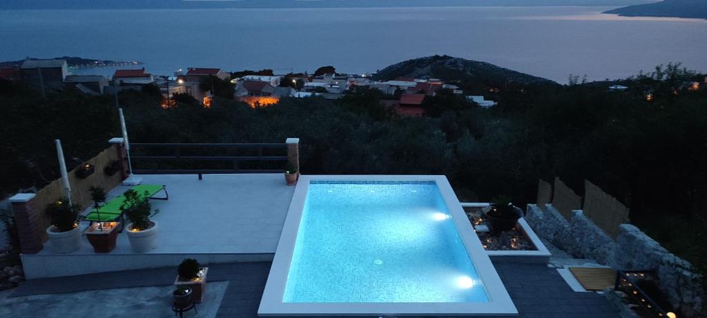 a swimming pool on the roof of a house at night at Holiday home Duje in Veliko Brdo