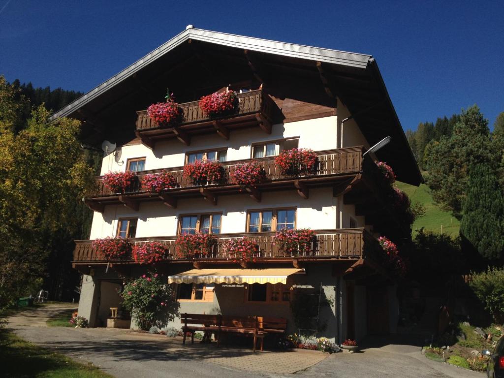 ein Gebäude mit Blumenkästen auf dem Balkon in der Unterkunft Bauernhof Bachgut in Mühlbach am Hochkönig