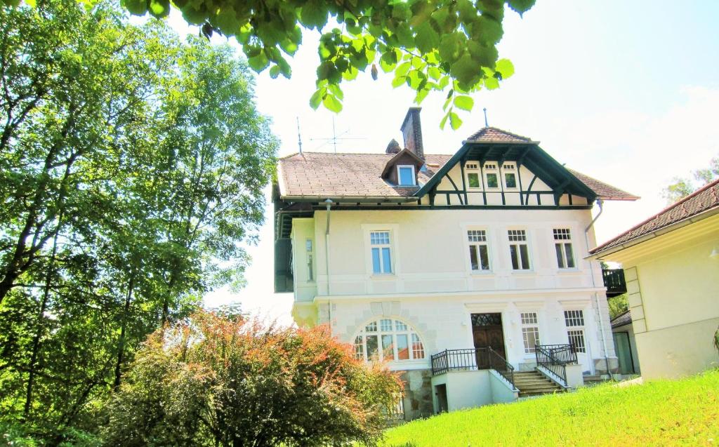 una casa vieja en una colina con árboles en Appartement Ambiente, en Waidhofen an der Ybbs