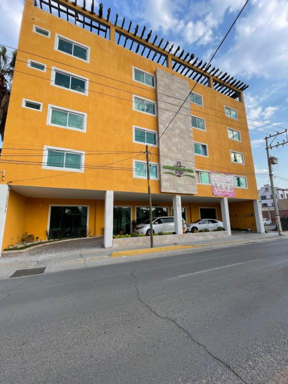een oranje gebouw op de hoek van een straat bij ABERDEEN HOTEL DOLORES HIDALGO in Dolores Hidalgo