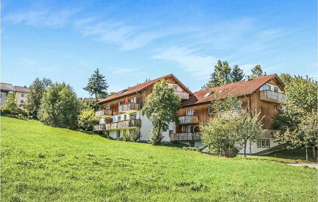ein großes Gebäude auf einem grasbewachsenen Hügel mit Bäumen in der Unterkunft Beautiful Apartment In Viechtach With Sauna in Viechtach