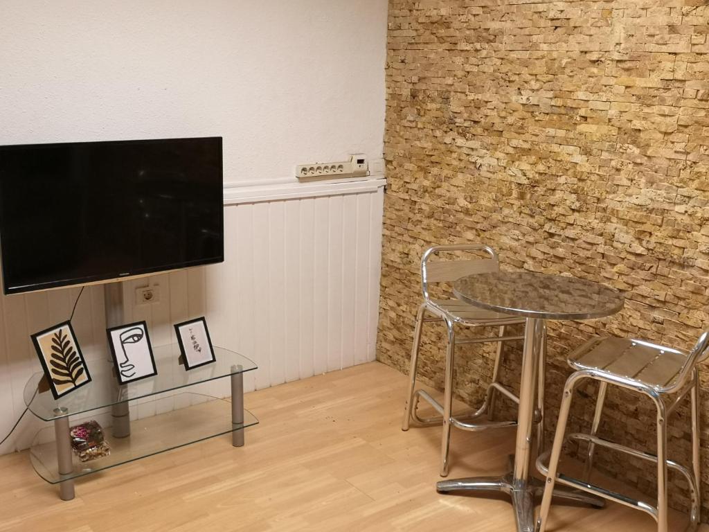 ein Wohnzimmer mit Tisch und Stühlen und einem Fernseher in der Unterkunft Acogedor apartamento con excelente ubicación. in Santa Cruz de Tenerife