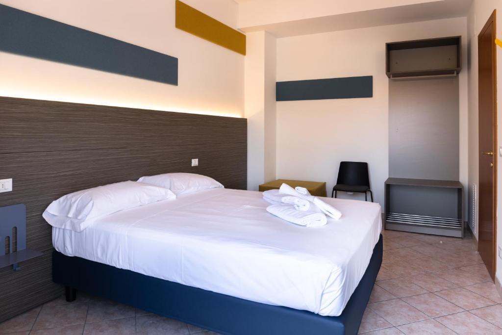 een slaapkamer met een groot bed met witte lakens bij Smart and Sea in Tortoreto Lido