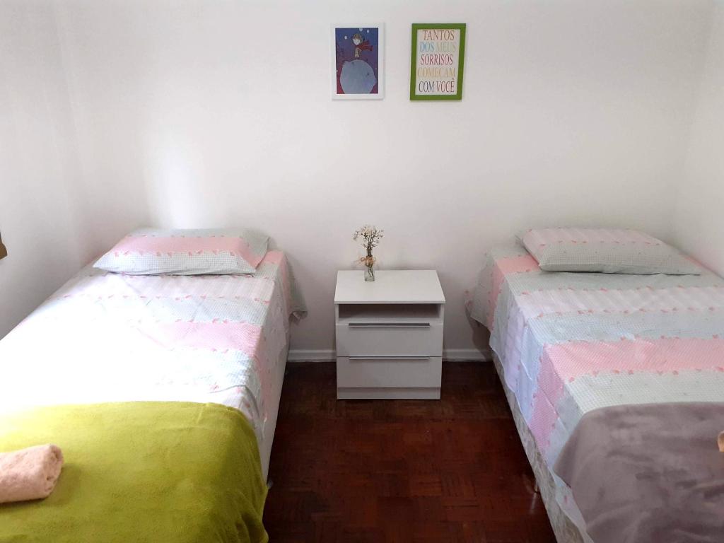 - 2 lits jumeaux dans une chambre avec une table blanche dans l'établissement Lindo quarto na Praia de Botafogo, à Rio de Janeiro