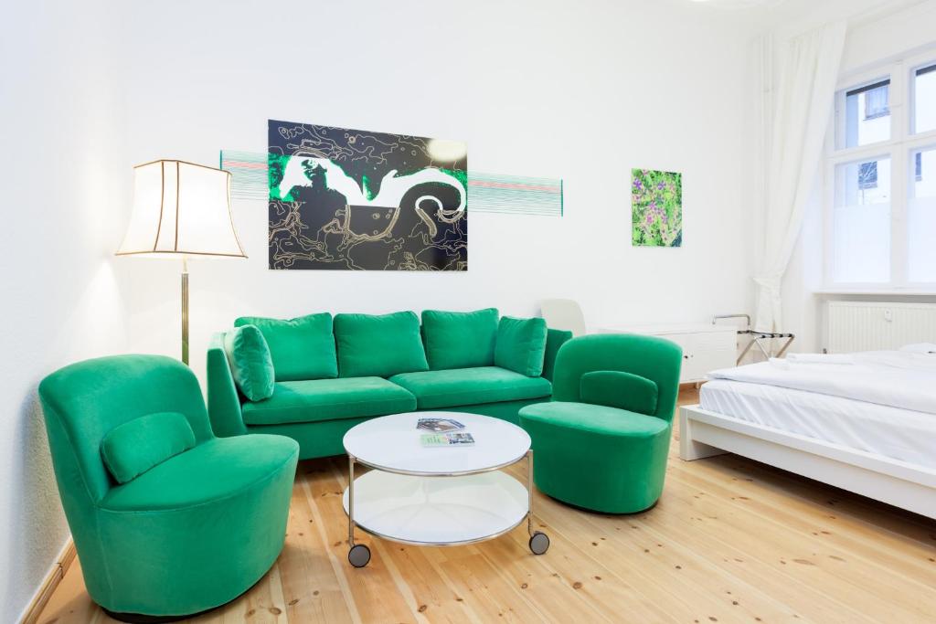 a living room with a green couch and two chairs at Apartment Berlin Zentrum in Berlin
