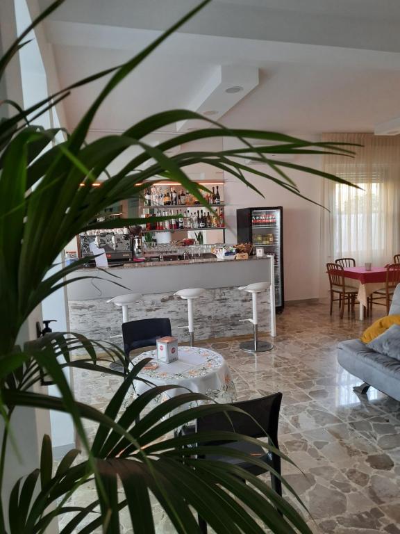 a living room with a table and a white piano at Hotel Barbiani in Riccione