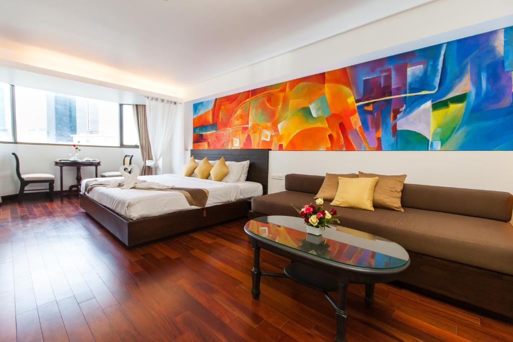 a living room with a couch and a painting at The Grand Sathorn in Bangkok