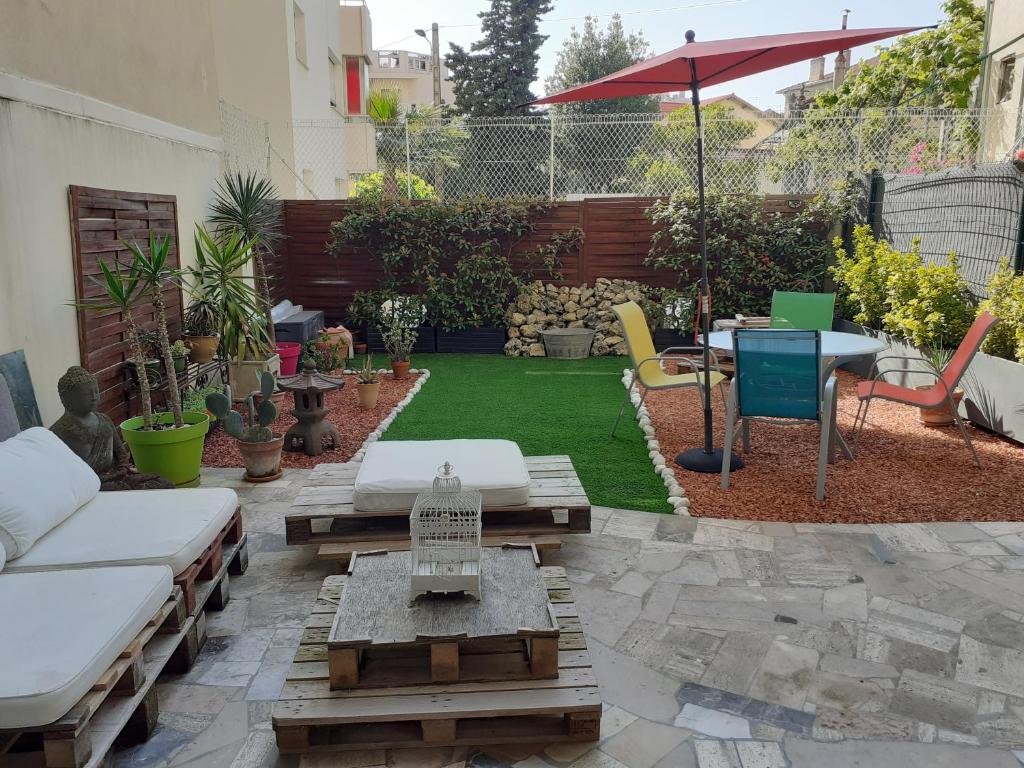 a backyard with a lawn with a table and chairs at Studio Terrasse Proche Palais des Festivals in Cannes