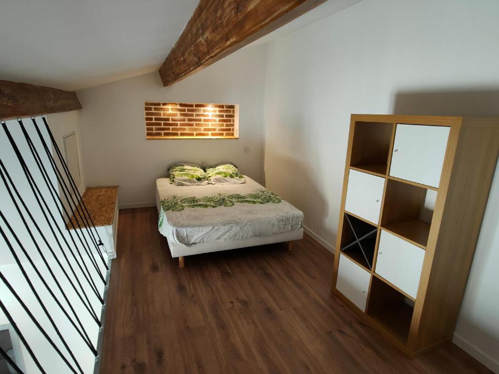 a small bedroom with a bed and a book shelf at Joli apparemment type Loft in Cavaillon