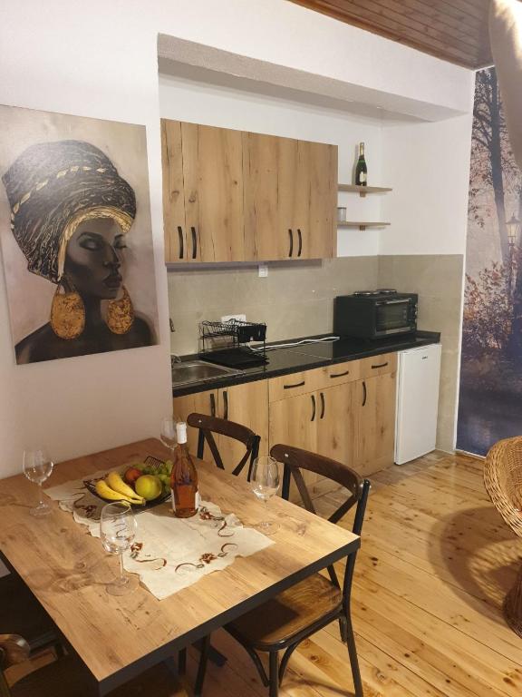 a kitchen with a table and a painting of a woman at Apartman_trile in Ulcinj