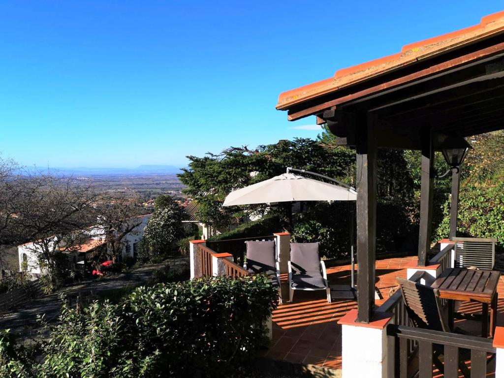 porche con sillas, sombrilla y vistas en Petit Charme, en Laroque-des-Albères