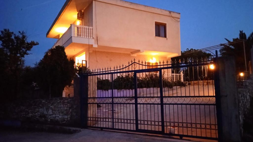 a house with a gate in front of it at Arsen Apartments in Sarandë