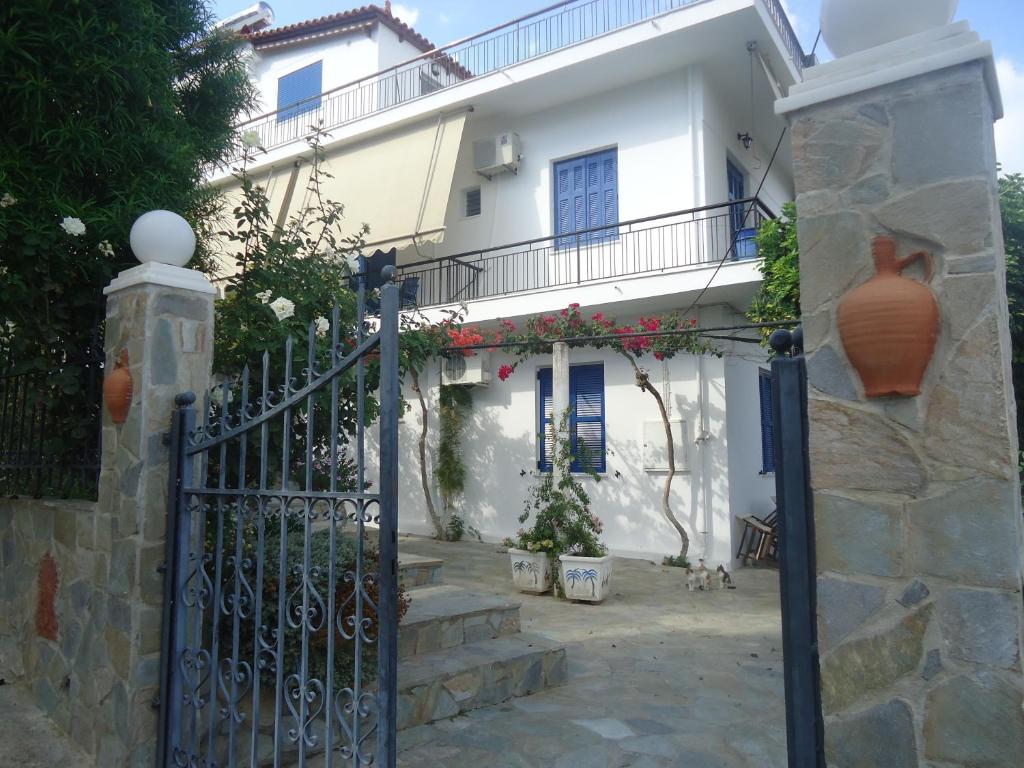 a white house with a gate in front of it at Villa Popi in Methana