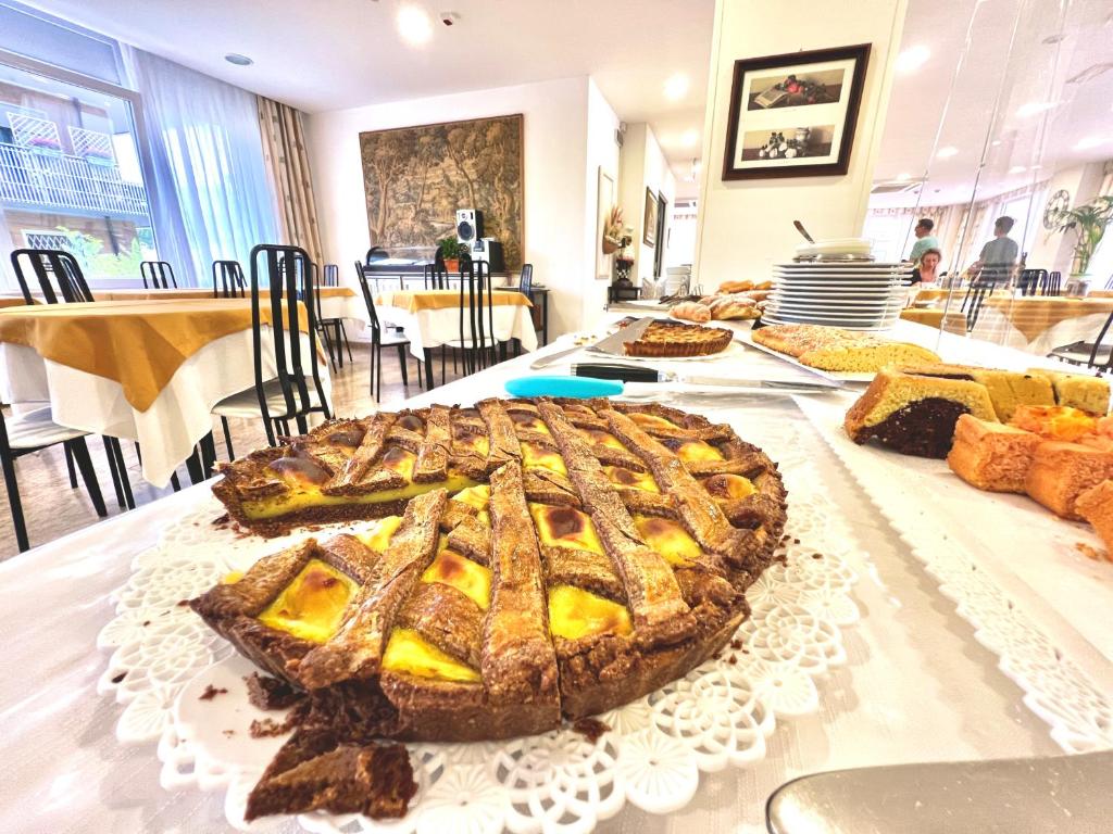einen Tisch mit einem Kuchen darüber in der Unterkunft Hotel B&B Montecarlo in Milano Marittima