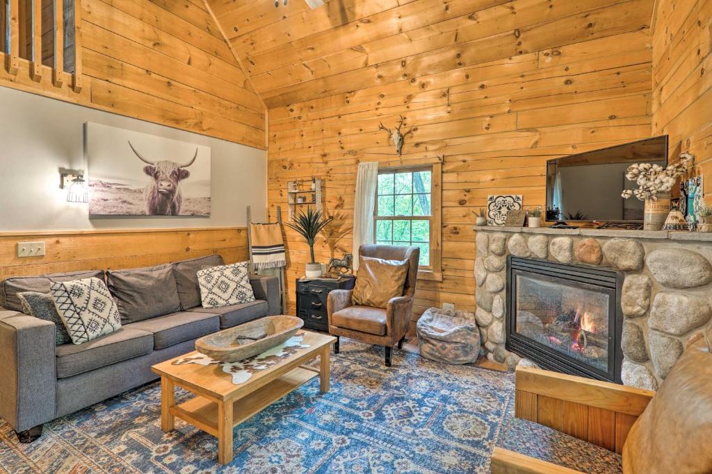 a living room with a couch and a fireplace at Cozy Retreat with Porch and Double JJ Resort Access! in Rothbury