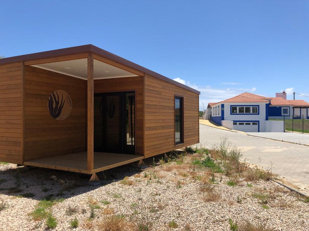 um pequeno edifício com um alpendre ao lado de uma estrada em São Torpes by Campigir em Sines