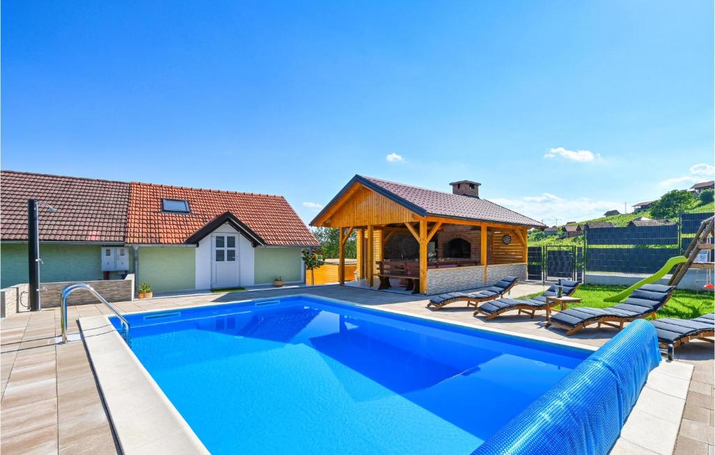 a swimming pool with a gazebo and a house at Nice Home In Vrhi Pregradski With Wifi, Outdoor Swimming Pool And Heated Swimming Pool in Pregrada