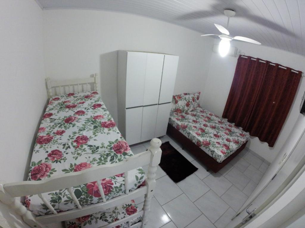 Cette petite chambre comprend deux lits, un lit et une fenêtre. dans l'établissement Morada da Lena 1, à Balneário Camboriú