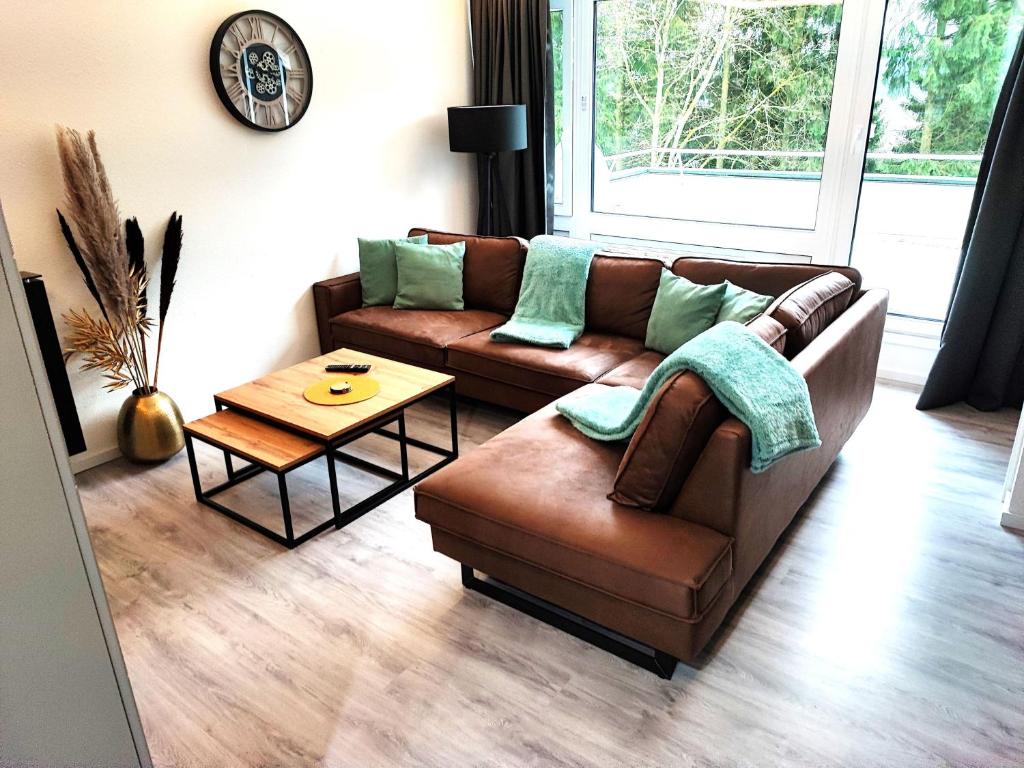 a living room with a couch and a table at Glamory Winterberg Ferienwohnung Pool Sauna Wifi 6 Personen near Lift Balkon PS4 in Winterberg