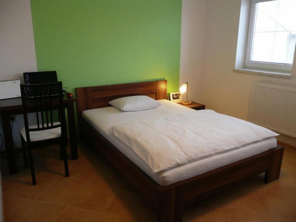 1 dormitorio con cama, escritorio y ventana en Hotel Pod Zelenou, en Český Těšín