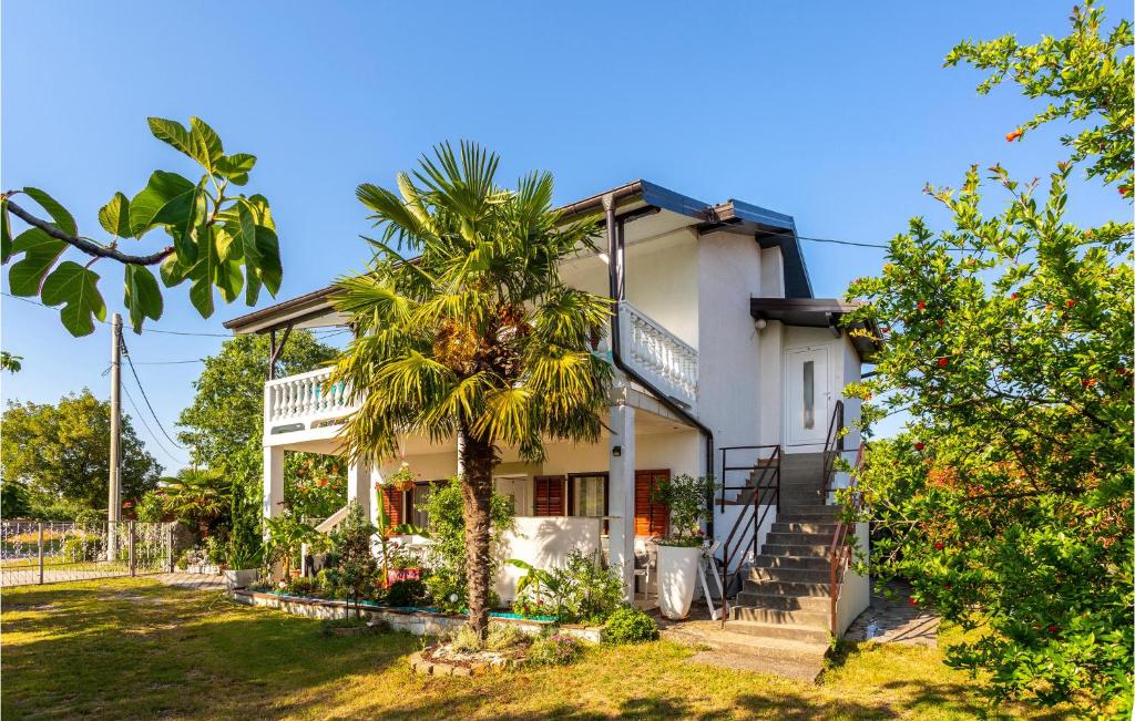 a house with a palm tree in front of it at Stunning Apartment In Gabonjin With House A Panoramic View in Gabonjin