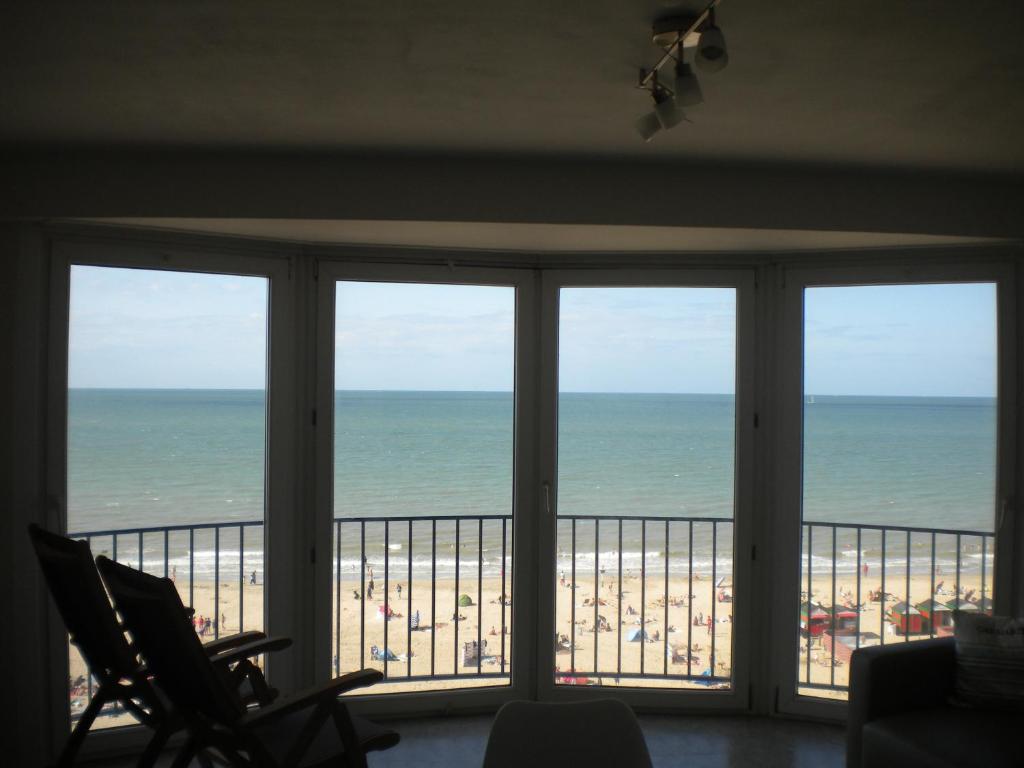 una vista sulla spiaggia da una camera con finestre di Apartment Sandeman a De Panne