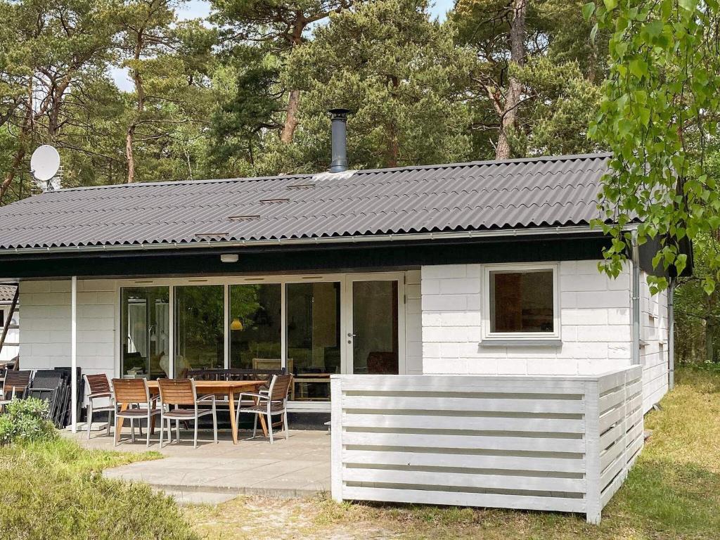 a small white house with a table and chairs at 6 person holiday home in Nex in Spidsegård