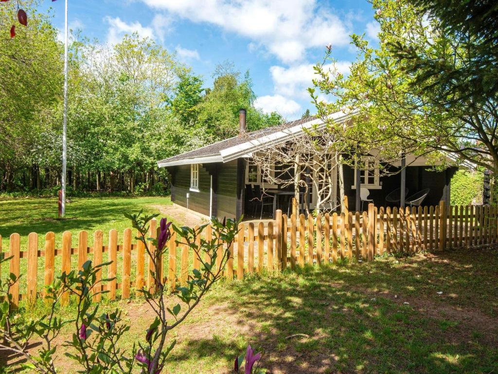 uma cerca de madeira em frente a uma casa em 6 person holiday home in F rvang em Fårvang