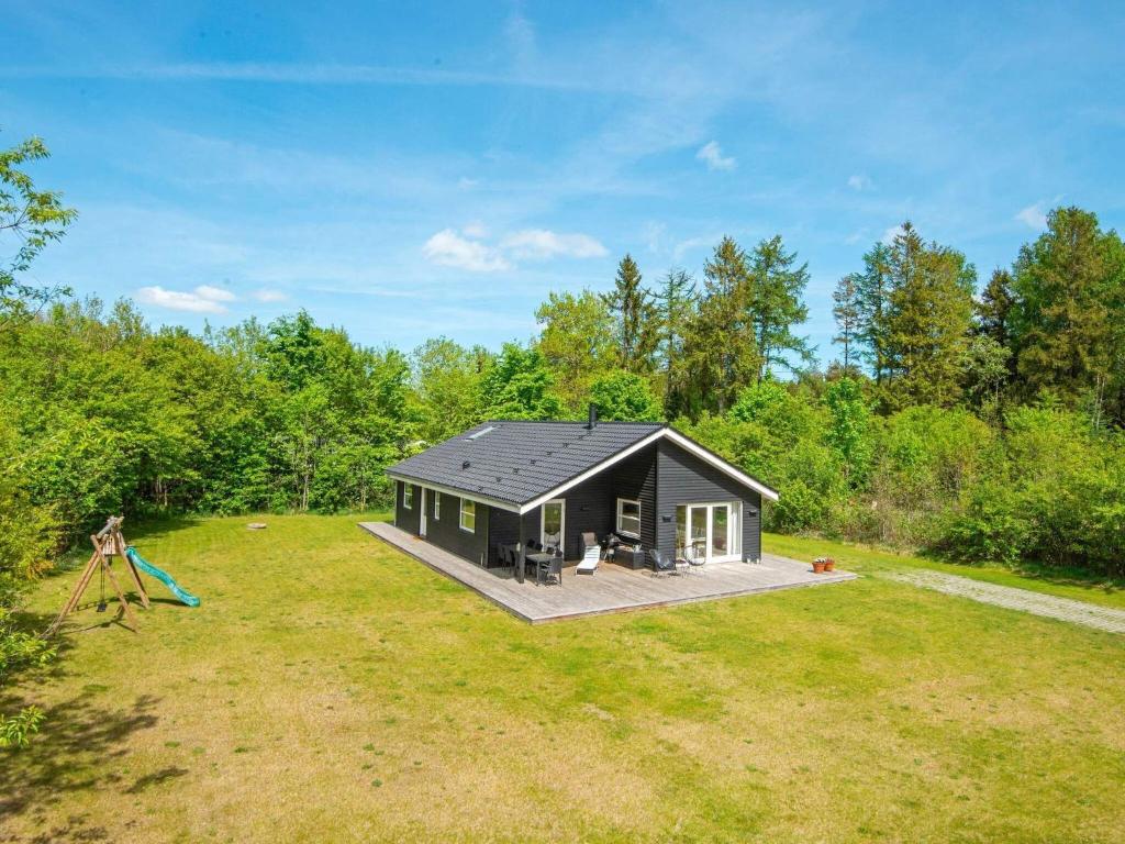 a black cabin in the middle of a yard at 8 person holiday home in Silkeborg in Silkeborg