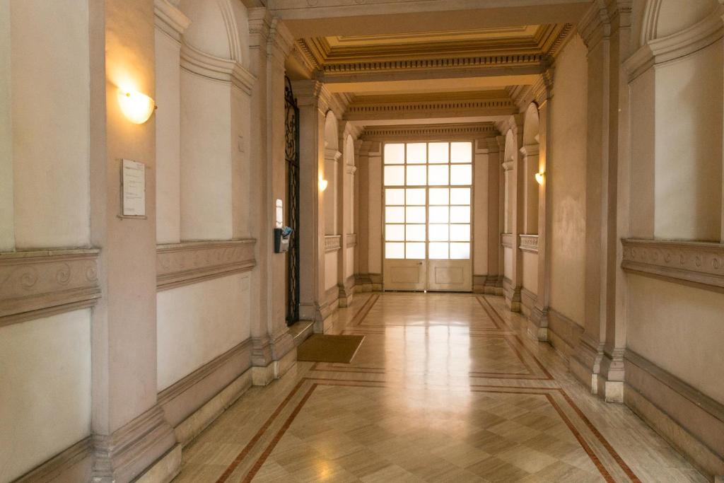 un pasillo vacío en un edificio con ventana en Allegria Fitzroy Cesr en Roma