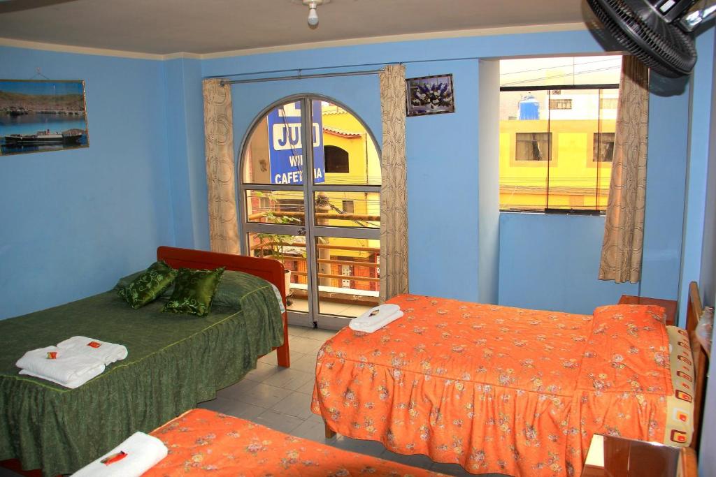 a room with two beds and a window at HOSTAL JUMI in Tacna