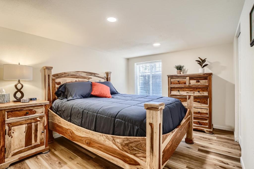 a bedroom with a wooden bed with a blue comforter at Sloans Lake Getaway Near Broncos & Downtown Denver in Lakewood