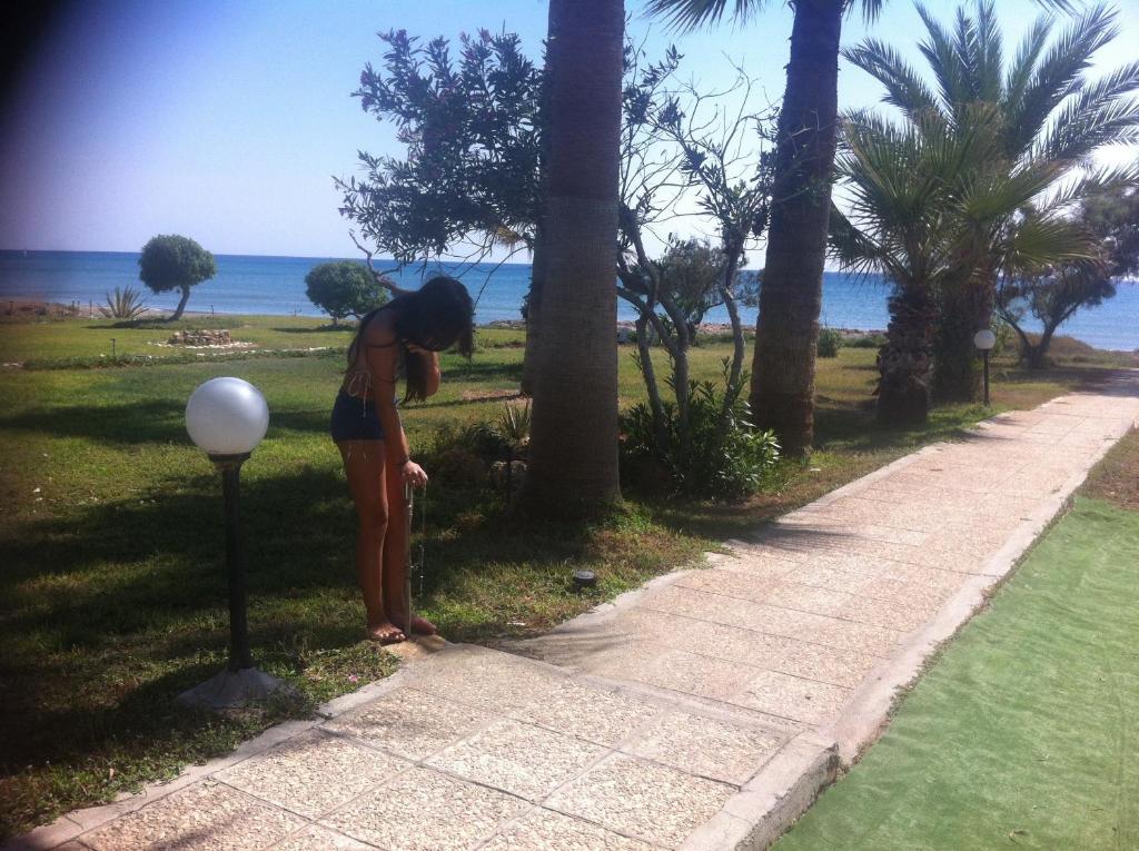 a woman is standing next to a golf ball at Sandy Beach Apartment 8 in Voroklini