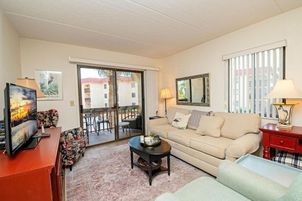 a living room with a couch and a tv at Unit 6202 - Ocean & Racquet Resort in Saint Augustine Beach