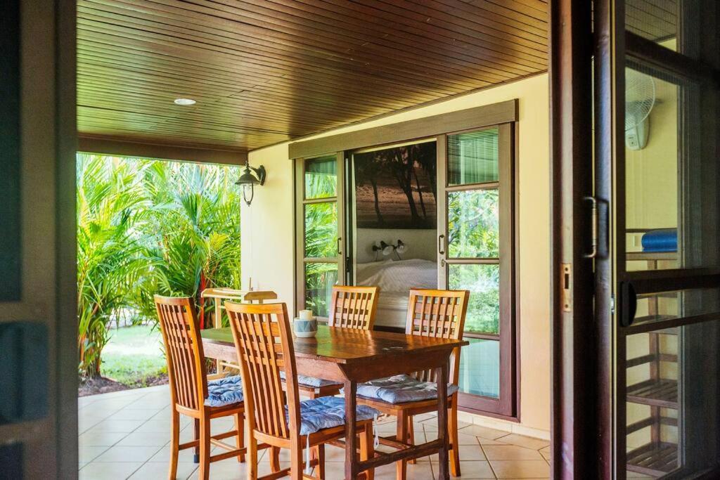 a dining room table and chairs on a patio at Family-friendly house, a few steps from the pool and close to the ocean. in Mae Pim