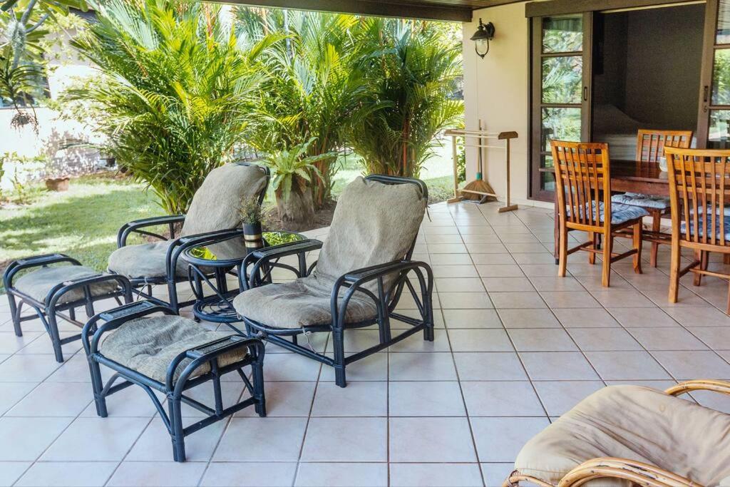 a group of chairs and a table on a patio at Family-friendly house, a few steps from the pool and close to the ocean. in Mae Pim