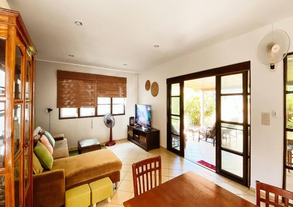 a living room with a couch and a table at Family-friendly house, a few steps from the pool and close to the ocean. in Mae Pim