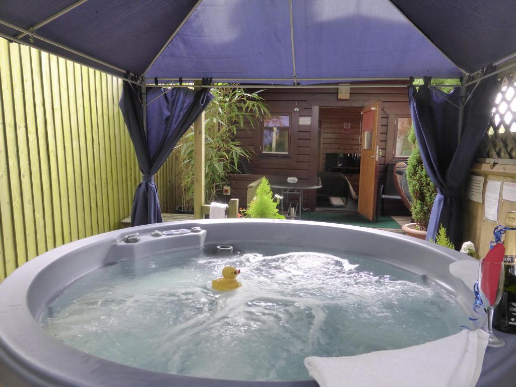 a bath tub with a rubber duck in it at Cypress Log Cabins Accommodation in Godshill