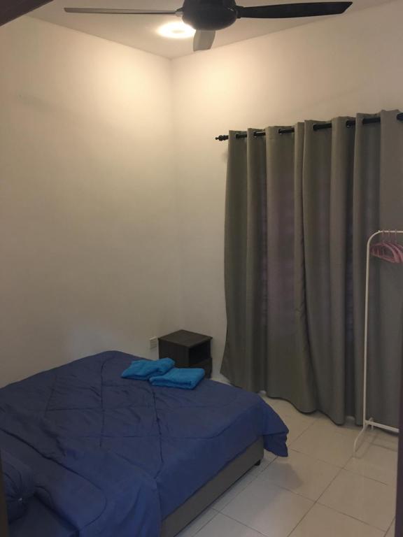 a bedroom with a bed and a ceiling fan at Fadi's Guesthouse at Bandar Baru Samariang in Kuching