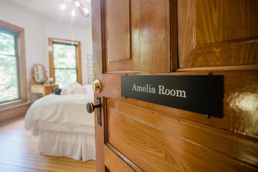 - un panneau sur une porte dans une chambre avec un lit dans l'établissement Amelia Room BW Boutique Hotel, à Central Lake