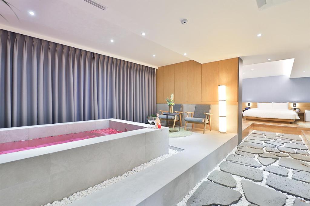 a living room with a large bathtub in the middle at Custom Hotel in Ulsan