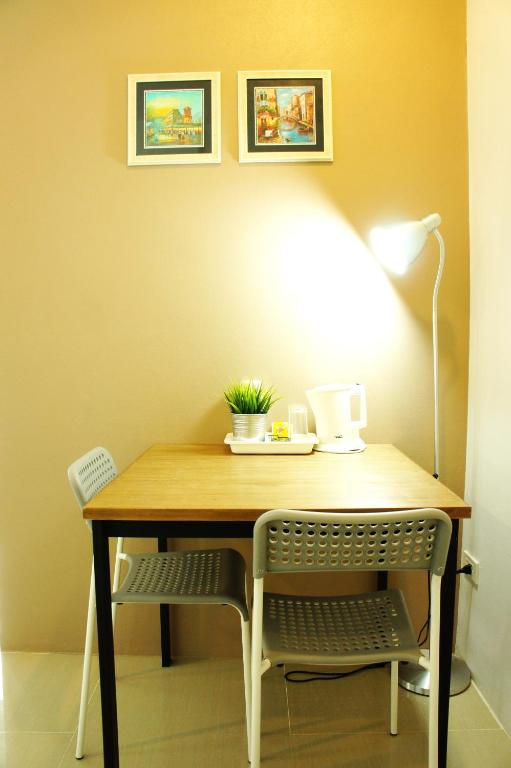 Compact two-person desk with lamp, kettle and small decorative plant.